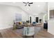 Bright living room with a brick fireplace, ceiling fan, light hardwood flooring, and neutral color furniture at 3208 Spruce Way, Atlanta, GA 30349