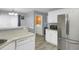 Modern kitchen with stainless steel appliances and breakfast bar, adjacent to laundry area at 3419 Allie Dr, Snellville, GA 30039