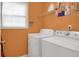 Bright laundry room with orange walls and includes a washer and dryer at 3419 Allie Dr, Snellville, GA 30039