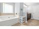 Bright bathroom features a soaking tub with tile surround and a window at 588 Joneus Dr, Mcdonough, GA 30252