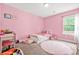 Pink bedroom with a twin bed, desk, and circular rug at 588 Joneus Dr, Mcdonough, GA 30252