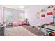 A light purple bedroom featuring a cozy rug, bright window, and playful decor at 588 Joneus Dr, Mcdonough, GA 30252