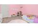 Bright pink bedroom with a desk, chair, bed with comforter, and a white door at 588 Joneus Dr, Mcdonough, GA 30252