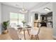 Sunlit dining room adjoining the kitchen, featuring a glass table and contemporary white chairs at 588 Joneus Dr, Mcdonough, GA 30252