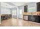 Bright kitchen and dining area with stainless steel dishwasher, dark cabinets, and wood laminate flooring at 588 Joneus Dr, Mcdonough, GA 30252