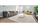 Bright living room with a plush gray sofa, white coffee table, and natural light from large windows at 588 Joneus Dr, Mcdonough, GA 30252