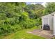 Private backyard space featuring a grill and partial fencing surrounded by lush landscaping and mature trees at 6178 Field Stone Dr, Douglasville, GA 30134
