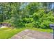 Lush backyard with mature trees, greenery, and a concrete patio, offering privacy at 6178 Field Stone Dr, Douglasville, GA 30134