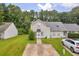 Charming home exterior with a long driveway and lush green lawn surrounded by a beautiful tree line at 6178 Field Stone Dr, Douglasville, GA 30134
