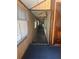 View of a hallway with wood-paneled walls, carpeted floors, and natural light coming from windows at 718 South Ave, Forest Park, GA 30297