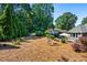 Spacious backyard with pine straw groundcover, mature trees, and charming decorative elements at 830 Club Chase Ct, Roswell, GA 30076