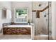 This luxury bathroom has a separate soaking tub, a glass shower and a large window at 830 Club Chase Ct, Roswell, GA 30076