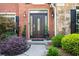 Charming brick home featuring an elegant front door with glass accents and manicured landscaping at 830 Club Chase Ct, Roswell, GA 30076