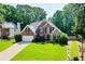 Inviting brick and stone home with lush lawn and mature trees at 830 Club Chase Ct, Roswell, GA 30076