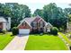 Charming brick home with a well-manicured lawn and lush landscaping at 830 Club Chase Ct, Roswell, GA 30076