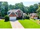 Beautiful brick home featuring manicured lawn and a two car garage at 830 Club Chase Ct, Roswell, GA 30076