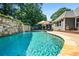 Sparkling swimming pool with stone accents, surrounded by lush landscaping and comfortable seating at 830 Club Chase Ct, Roswell, GA 30076