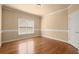 Bright bedroom featuring hardwood floors, neutral paint, and ample natural light from the window at 10565 Highgate Manor Ct, Duluth, GA 30097