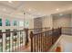 A hallway with hardwood floors, a stone wall accent, and many windows allowing for natural light at 10565 Highgate Manor Ct, Duluth, GA 30097