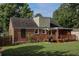 A charming brick home features a wooden deck, a grill, and a spacious lawn, perfect for outdoor gatherings and relaxation at 2432 Saint Patrick Se St, Atlanta, GA 30317