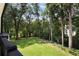A lush, manicured backyard as seen from a private balcony, surrounded by mature trees at 1155 Peachtree Battle Nw Ave, Atlanta, GA 30327