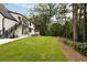 Beautiful backyard and home exterior with abundant grass and a wooded area at 1155 Peachtree Battle Nw Ave, Atlanta, GA 30327