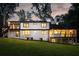 A backyard with lush green grass and the home's windows letting out plenty of light at 1155 Peachtree Battle Nw Ave, Atlanta, GA 30327