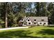 A beautiful home sits atop a hill with trees surrounding it, a driveway and a mailbox at 1155 Peachtree Battle Nw Ave, Atlanta, GA 30327
