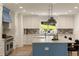 A stylish kitchen with white cabinets, a blue island, stainless steel appliances, and a large window at 1155 Peachtree Battle Nw Ave, Atlanta, GA 30327