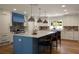 Bright kitchen featuring a large island, stainless steel pendant lights, and white and blue cabinets at 1155 Peachtree Battle Nw Ave, Atlanta, GA 30327