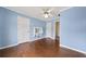 This cozy bedroom has wood floors, blue walls, and a ceiling fan at 11 Chad Ct, Mcdonough, GA 30253