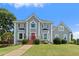 Elegant two-story home with a red front door, contrasted by a lush green lawn and mature landscaping at 11 Chad Ct, Mcdonough, GA 30253