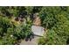 Overhead shot shows the property's layout, outbuildings, and ample parking, all encompassed by a dense canopy of mature trees at 261 Clayton Trl, Canton, GA 30114
