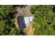 Aerial view of the property showcases the house, outbuildings and parking areas surrounded by lush green trees at 261 Clayton Trl, Canton, GA 30114