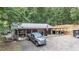 Aerial view of property with large garage, truck parked in driveway, and wooded landscape at 261 Clayton Trl, Canton, GA 30114