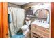 Updated bathroom features modern vanity, decorative mirror, and stylish shower curtain at 261 Clayton Trl, Canton, GA 30114