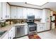 A view of the kitchen features stainless steel appliances, tile backsplash and white cabinets at 261 Clayton Trl, Canton, GA 30114