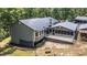 A rear exterior view shows a metal roof, enclosed porch, open deck and wooded lot at 261 Clayton Trl, Canton, GA 30114