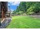 Expansive backyard with lush lawn, mature trees, and a view of the covered patio and screened porch at 3117 Blowing Wind Nw Ct, Acworth, GA 30101
