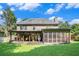 Spacious backyard showcasing the home's screened porch, covered patio, and lush green lawn at 3117 Blowing Wind Nw Ct, Acworth, GA 30101