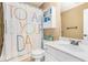 Well-lit bathroom featuring a shower with colorful curtain, vanity, and ample storage at 3117 Blowing Wind Nw Ct, Acworth, GA 30101