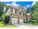 Angle view of charming two-story home featuring a brick and siding exterior, well-manicured lawn, and an attached two-car garage at 3117 Blowing Wind Nw Ct, Acworth, GA 30101