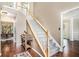 Inviting foyer featuring hardwood floors, a staircase with white banisters, and views into the dining and living areas at 3117 Blowing Wind Nw Ct, Acworth, GA 30101