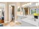 Bright bathroom featuring double sinks, white cabinets, and views into the bedroom at 3117 Blowing Wind Nw Ct, Acworth, GA 30101