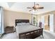 Comfortable main bedroom featuring a tray ceiling, ceiling fan, and en suite bathroom at 3117 Blowing Wind Nw Ct, Acworth, GA 30101