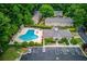 Aerial view of the community's pool and clubhouse, surrounded by lush greenery and parking at 405 Brighton Pt, Atlanta, GA 30328