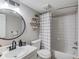 Bathroom with a modern sink, round mirror, and a shower/tub combo with tiled walls at 405 Brighton Pt, Atlanta, GA 30328