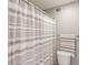 Cozy bathroom featuring a toilet, towel rack, and a white and gray striped shower curtain at 405 Brighton Pt, Atlanta, GA 30328