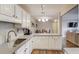 Well-lit kitchen with white cabinets, stainless steel sink, and view into the dining and living rooms at 405 Brighton Pt, Atlanta, GA 30328