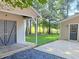 Backyard featuring matching outbuildings with dark doors and beautiful, landscaped grounds at 413 Old Brock Rd, Rockmart, GA 30153